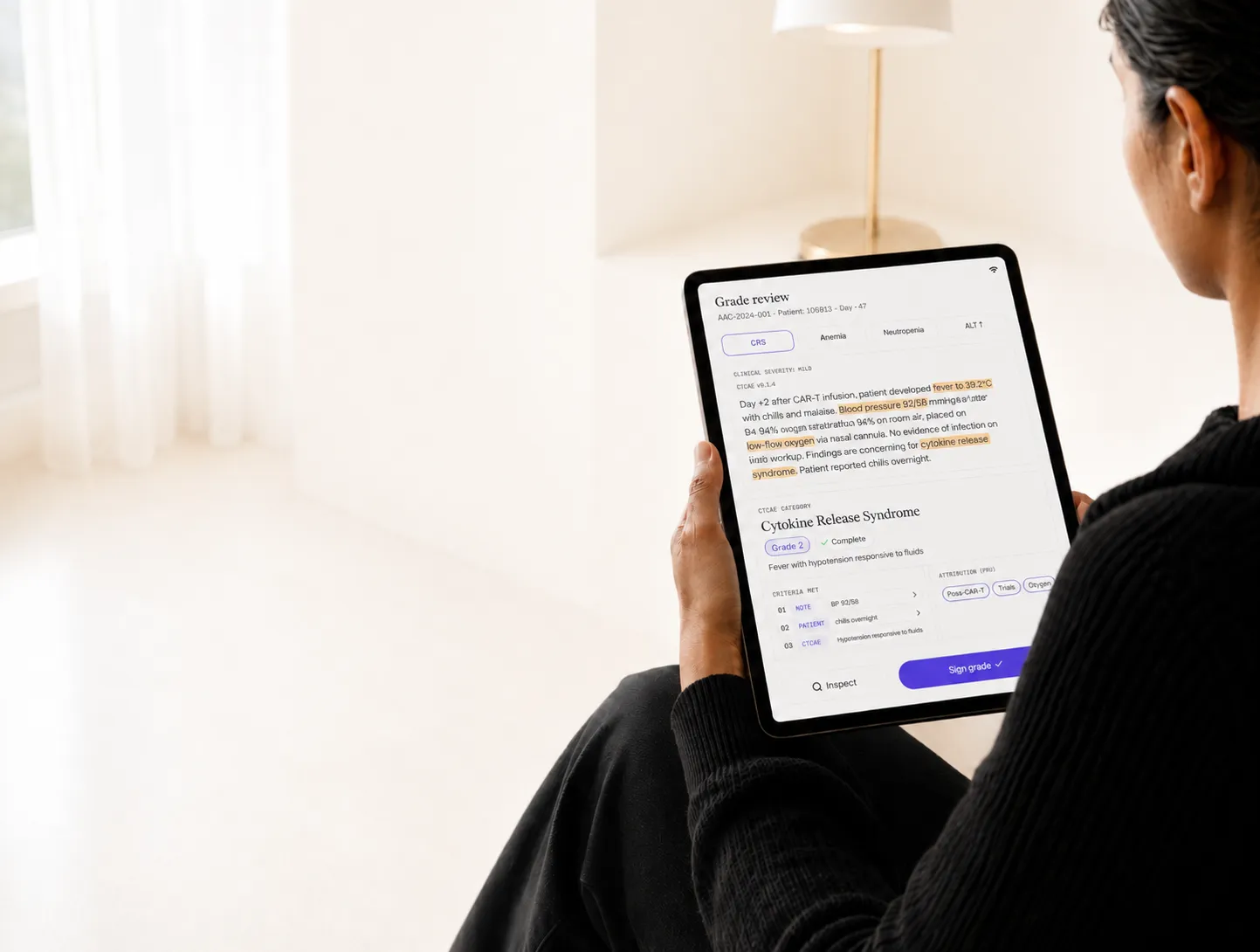 Editorial photo of a clinician reviewing CTCAE grades on a tablet, paper-tone treatment.